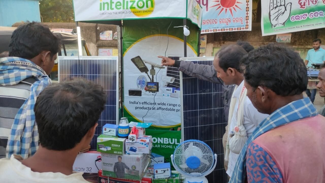 Villagers gathered around the Intelizon kiosk for a solar panel and fan demo